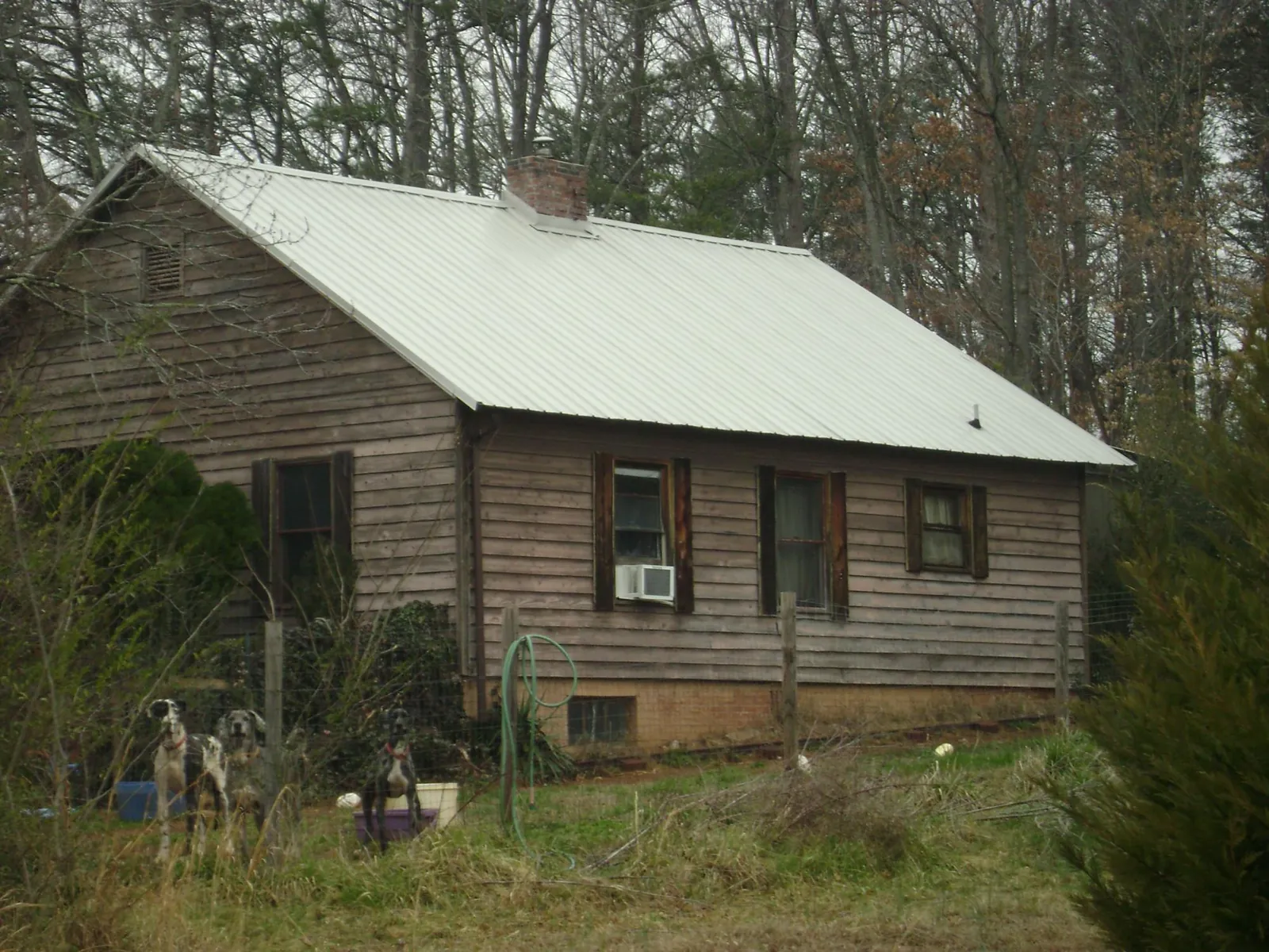 White metal roof on an old wood sided farmhouse, from a Metal Roof Installation job in Glenwood Landing